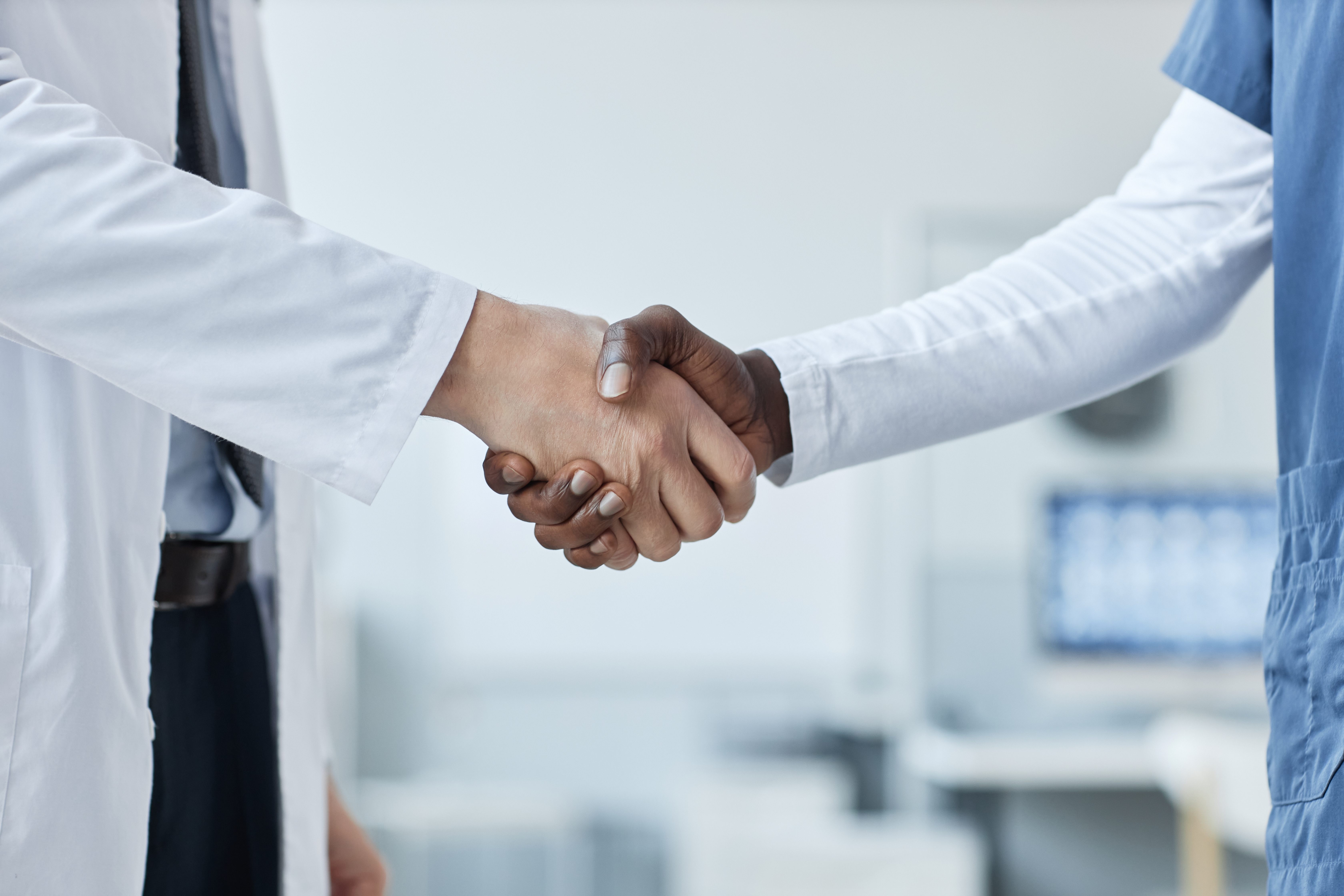 Handshake,Of,Two,Intercultural,General,Practitioners,Standing,In,Front,Of