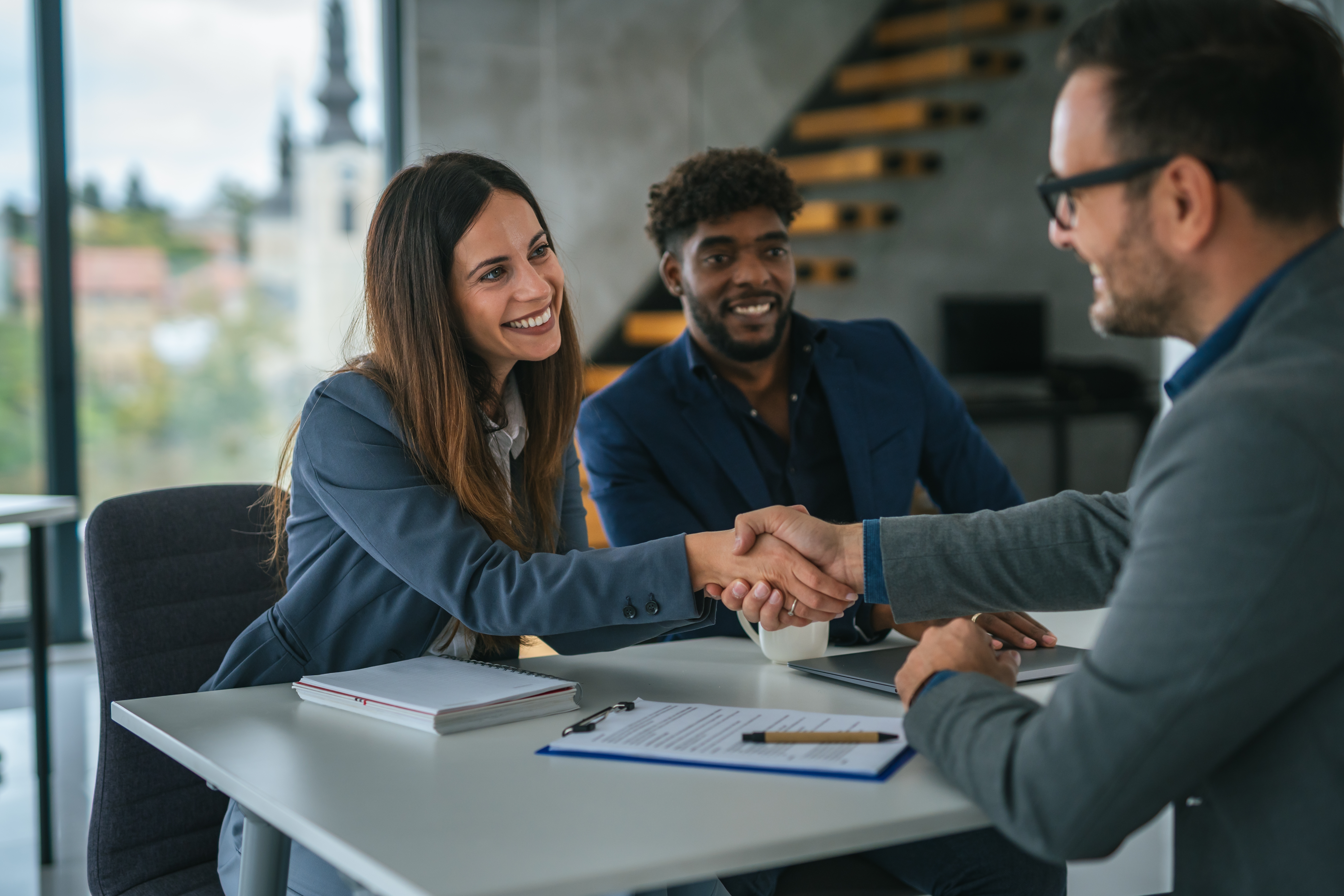 Three,Business,Professionals,Are,Shaking,Hands,,Concluding,A,Deal,Or